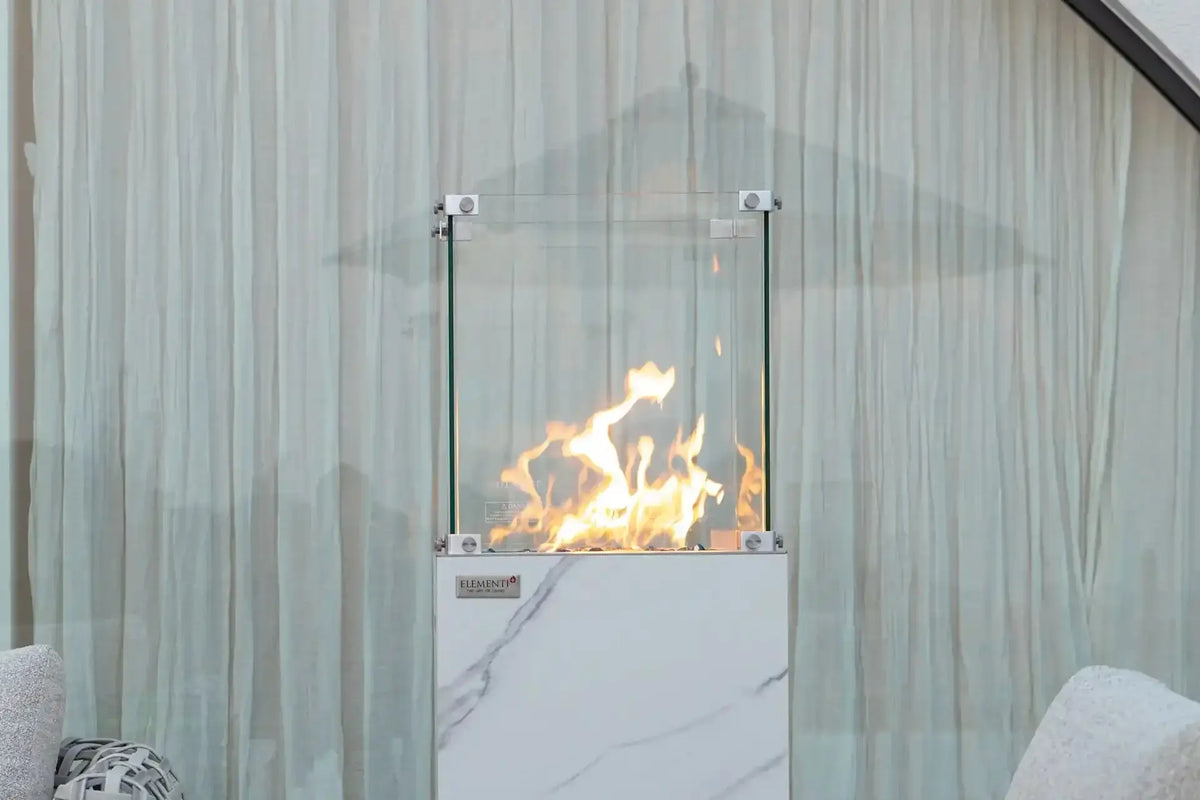 YUKON Marble Porcelain Dining Table - Bianco White B fire pit with glass enclosure and flames, perfect for outdoor settings.